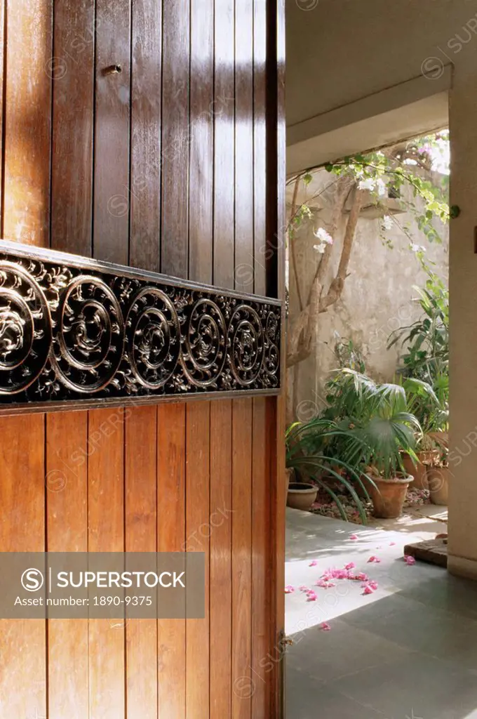 A modern front door decorated with a 400 year old piece of wood carving in 1970s concrete structured home, Ahmedabad, Gujarat state, India, Asia