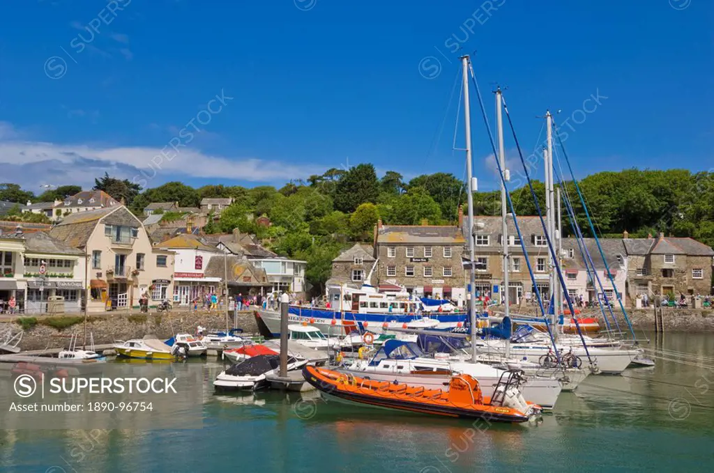 Busy tourist shops, small boats and yachts at high tide in Padstow harbour, Padstow, North Cornwall, England, United Kingdom, Europe