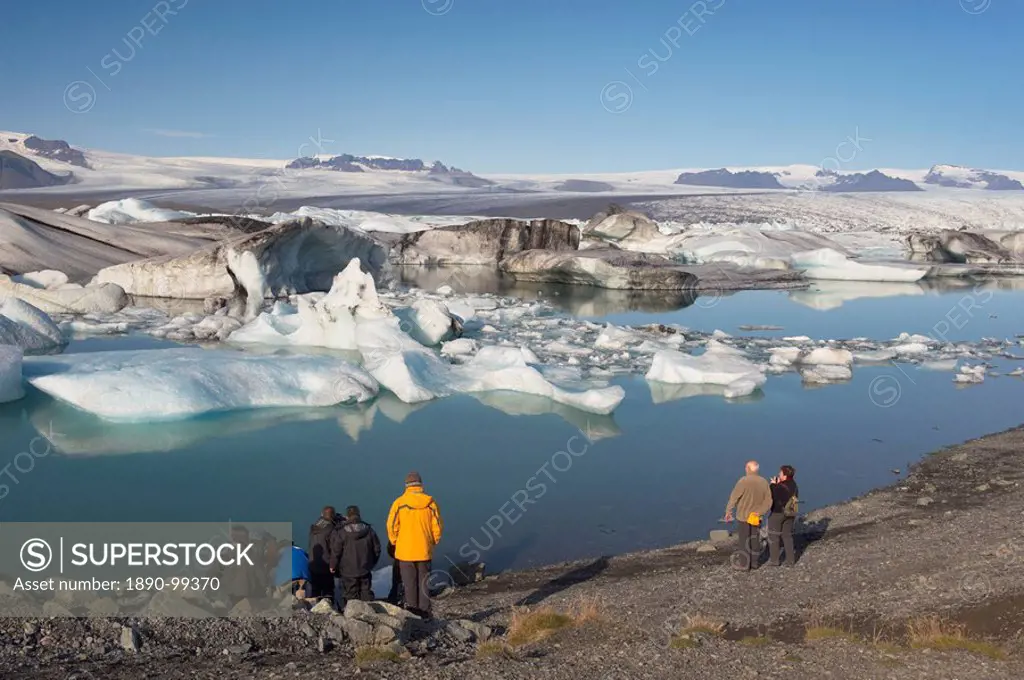 Tourists viewing icebergs in Jokulsarlon glacial lagoon, Oraefajokull glacier in the distance, East Iceland, Iceland, Polar Regions