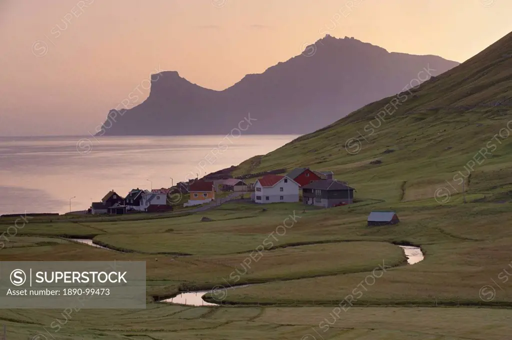Houses at Elduvik at sunrise, with view across Funningsfjordur of Kalsoy cliffs of Nestindar, 788m, and Borgarin, 537m, Eysturoy, Faroe Islands Faroes...