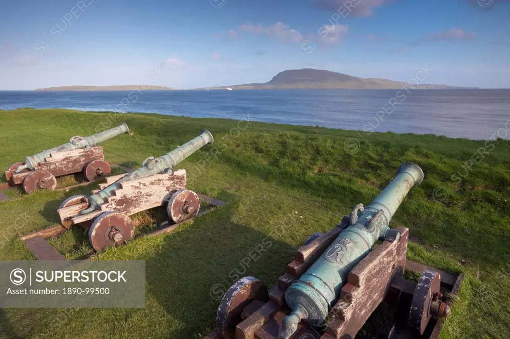 Skansin fort, old fort guarding Torshavn and its harbour, with old brass cannons, Second World War British marine guns and lighthouse, Nolsoy in the d...
