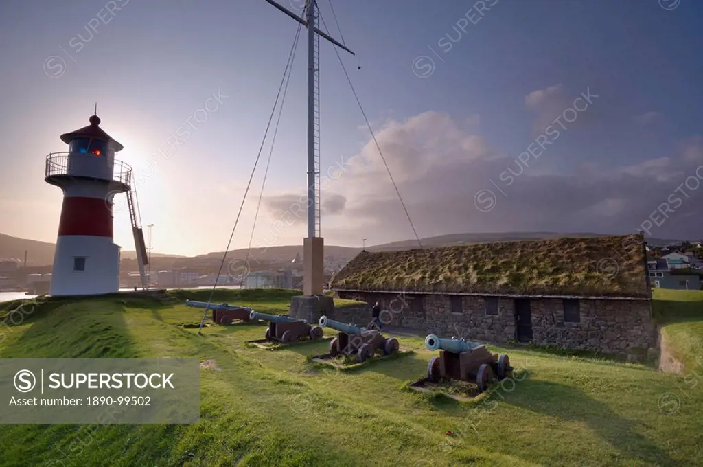Skansin fort, old fort guarding Torshavn and its harbour old brass cannons, WW2 british marine guns and lighthouse, Nolsoy in the distance, Torshavn, ...