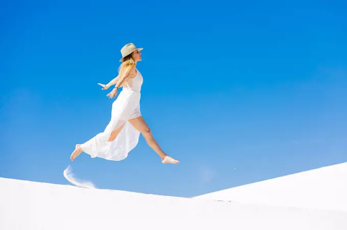 Woman jumping on the Gypsum Sand Dune, White Sands, New Mexico, United States of America, North America