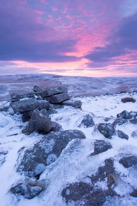 Beautiful sunrise in winter over a frozen snow covered moorland, Belstone Tor, Dartmoor, Devon, England, United Kingdom, Europe