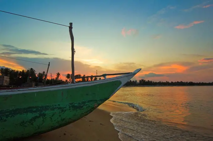 Outrigger boat at sunset at this fishing beach and popular tourist surf destination, Arugam Bay, Eastern Province, Sri Lanka, Asia