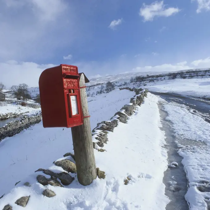 Traditional Red Postbox in a rural setting in the snow, North Yorkshire, England, United Kingdom, Europe