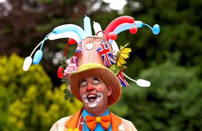 A clown laughing during a community picnic where local groups are providing musical and dance entertainment to celebrate the ethnic diversity of West ...