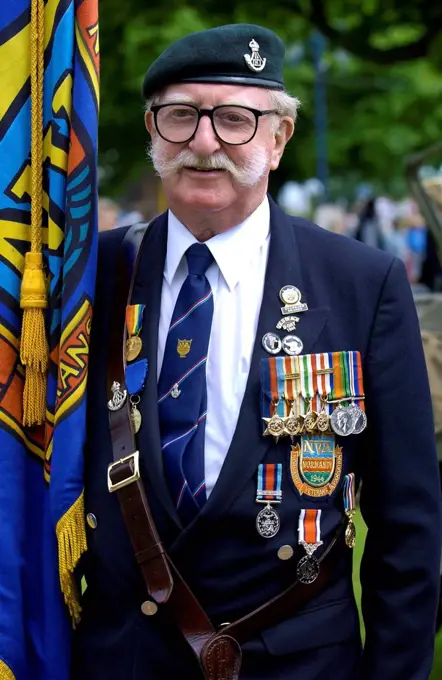 Veteran with handlebar moustache, beret, medals and flag in a parade of Veterans of the D-Day Landings at the start of the 60th Anniversary Commemorat...