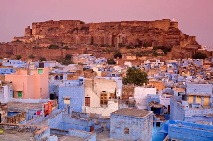 Elevated view over colorful houses of the Blue City towards Meherangarh Fort, Jodhpur, Western Rajasthan, India, Asia