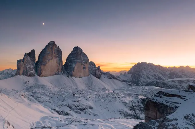 Sunset over Tre Cime di Lavaredo and Monte Cristallo covered with snow in autumn, Dolomites, border of South Tyrol and Veneto, Italy, Europe