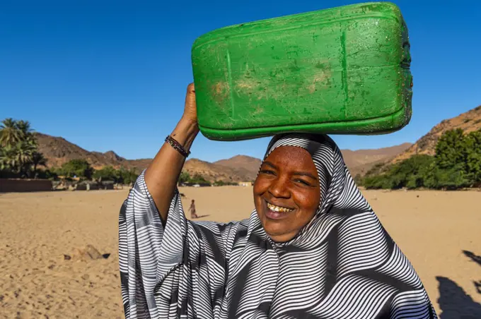 Woman carrying a water container on her head, Oasis of Timia, Air Mountains, Niger, Africa