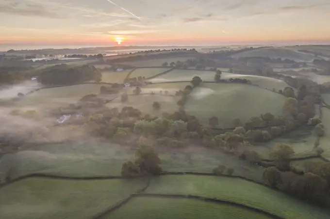 Misty spring sunrise over rolling countryside, South Tawton, Devon, England, United Kingdom, Europe