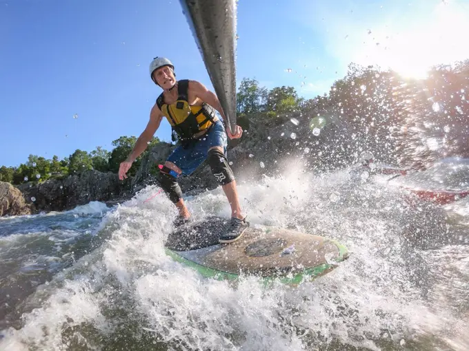 Photographer Skip Brown stand up paddle surfs challenging whitewater below Great Falls of the Potomac River, border of Virginia and Maryland, United States of America, North America
