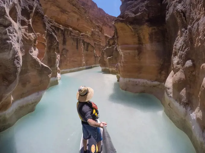 Photographer Skip Brown on a stand up paddle board at the mouth of Havasu Creek in the Grand Canyon, Arizona, United States of America, North America