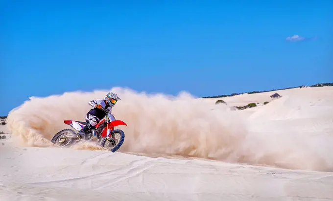 Trial bike rider kicking up sand at the sand dunes of Lancelin, Western Australia, Australia, Pacific