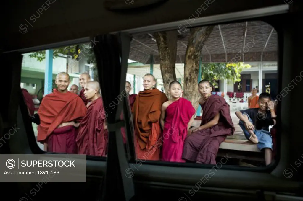 Monks viewed through the window of a car, Myanmar