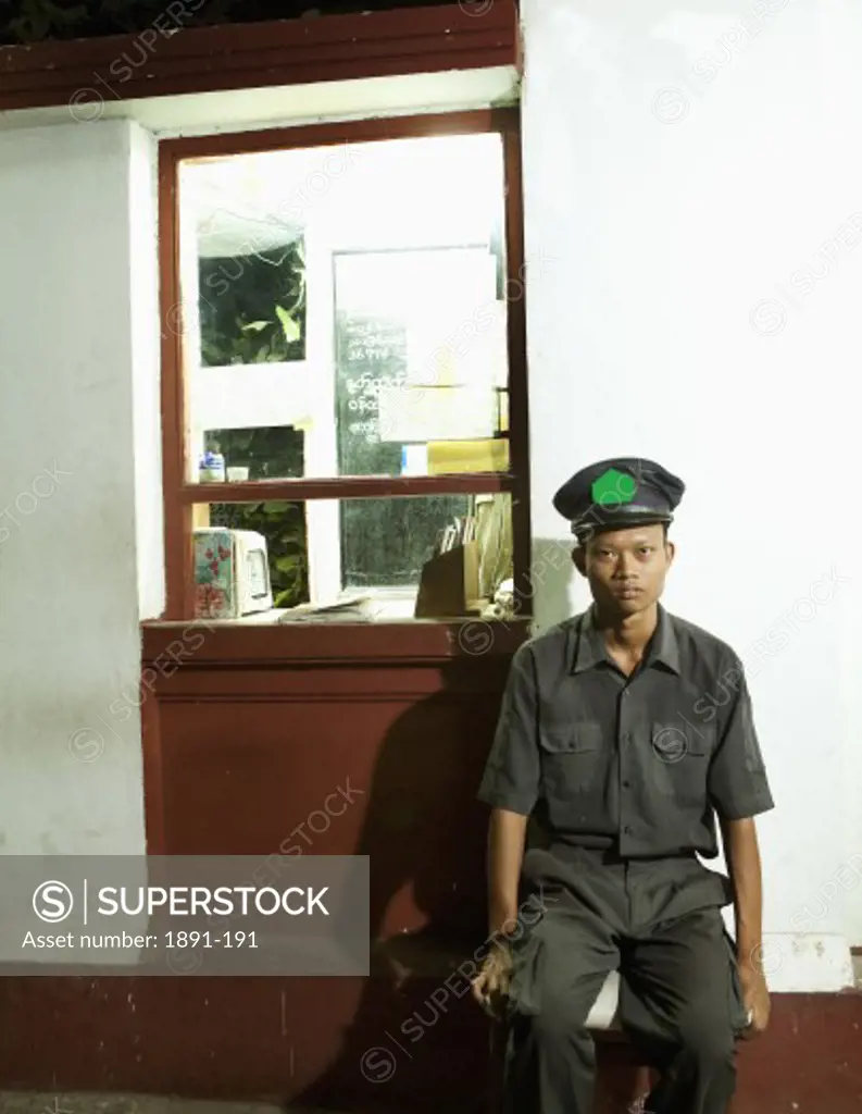 Security guard sitting outside a store, Myanmar