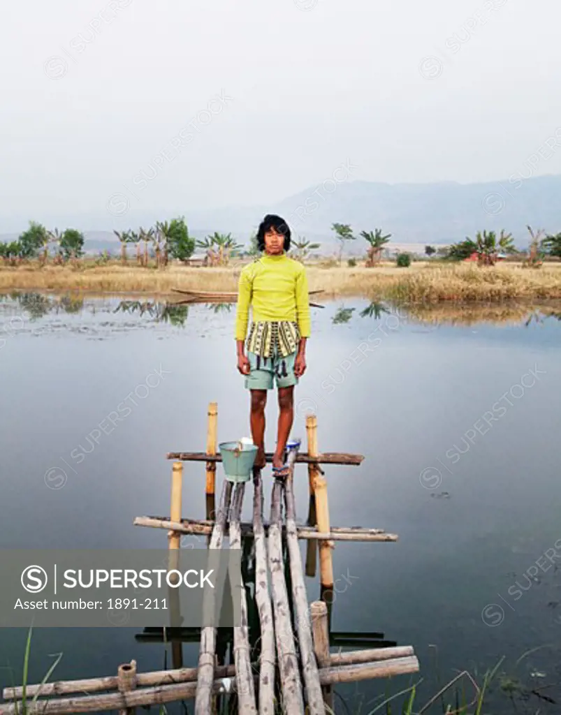 Boy standing on a pier, Myanmar