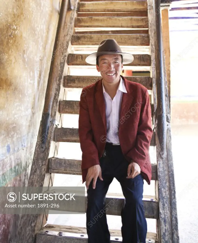 Man sitting on steps and smiling, Tibet