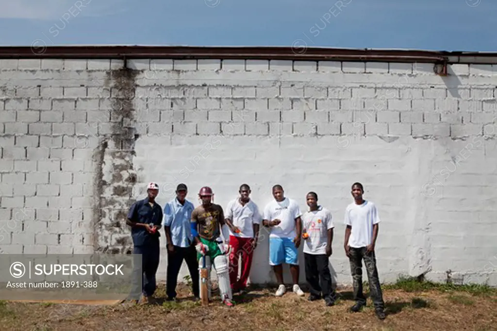 Cricket players standing in front a wall, Jamaica