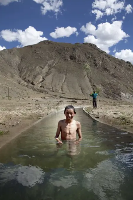 Boy taking bath in a Creek, Tibet,