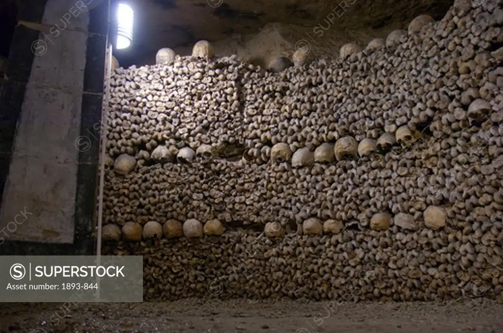 Human skulls lining the walls of the ancient Catacombs in Paris, Ile-de-France, France