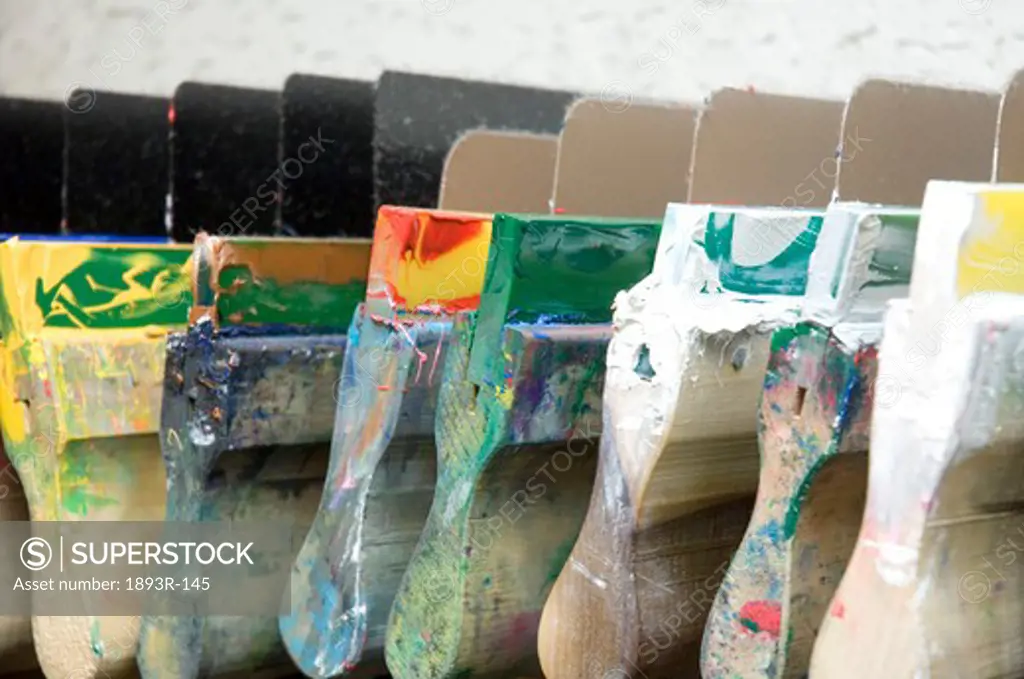 Row of squeegees covered in ink