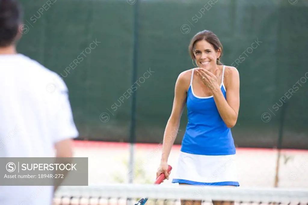 Young couple playing tennis in the court of a tourist resort