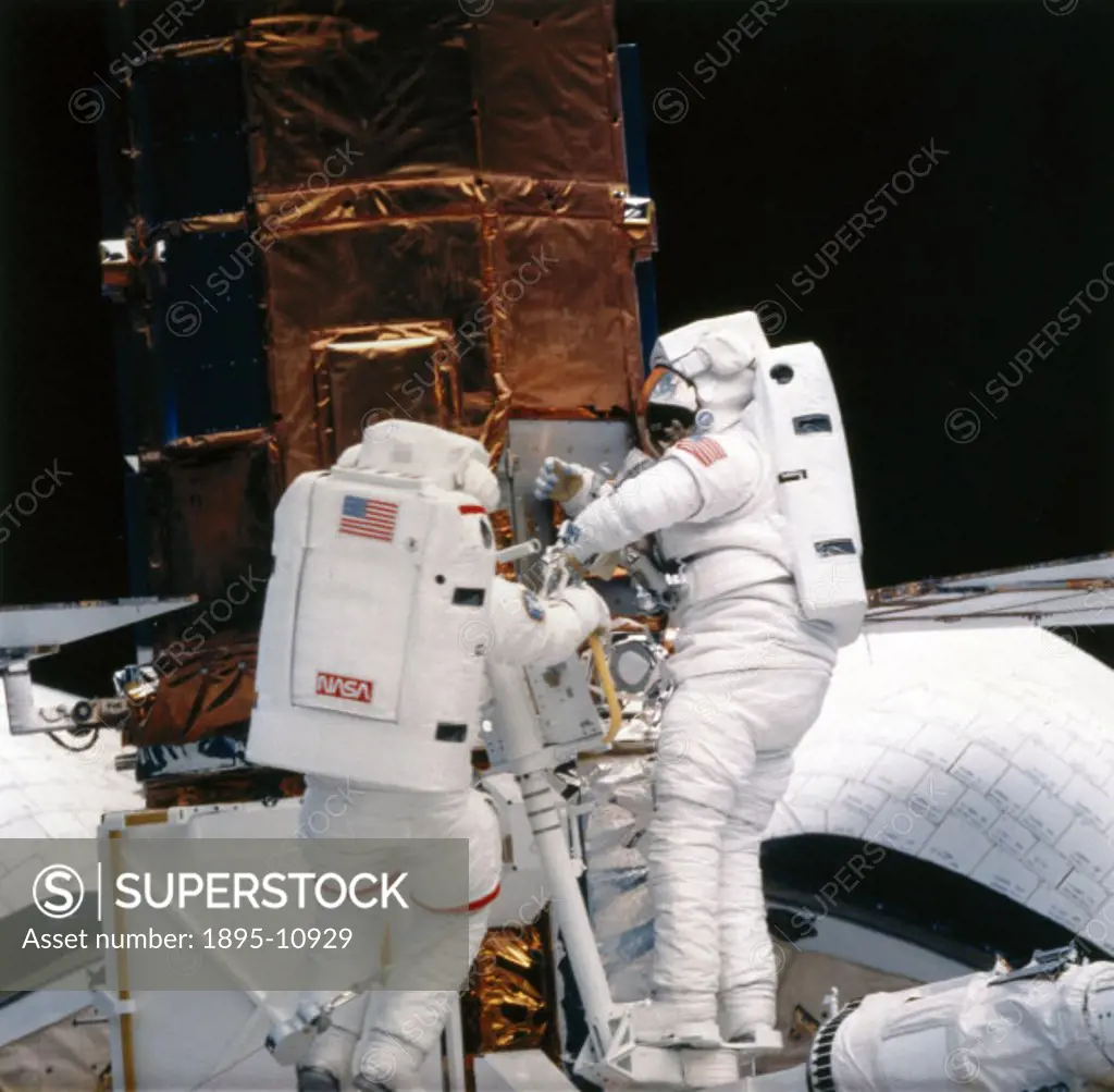 Astronauts George Nelson and James van Hoften with the satellite in the cargo bay of the Space Shuttle Challenger. During Shuttle mission 41-C, launch...