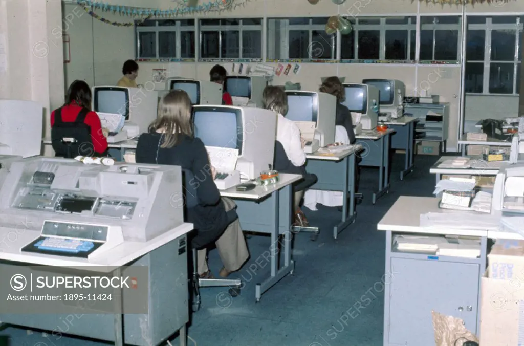 Clerks inputting data on sales in the computer section at the offices of Mothercare.