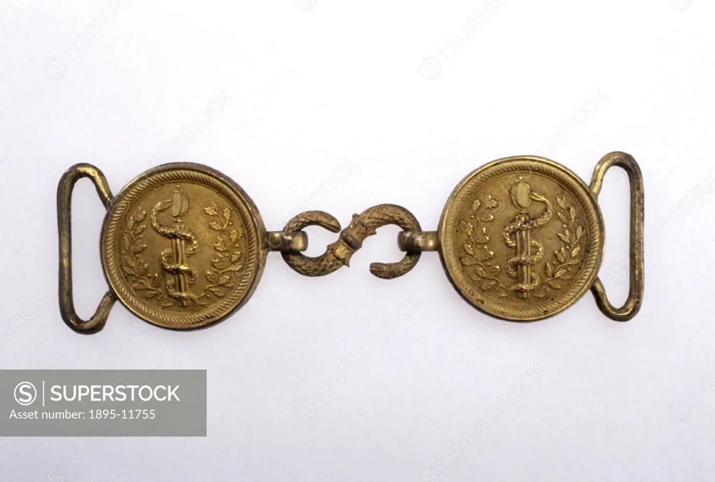 The buckle consists of two discs with an embossed caduceus and foliage, linked by a serpent made of ormolu. It is in the style worn by medical officer...