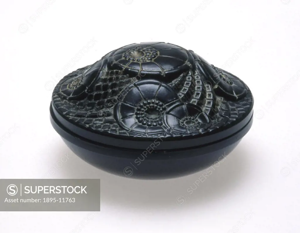 This black circular container has curved base and domed lid decorated with moulded stylised flowers which may be poppies. It was designed by Eduard Fo...