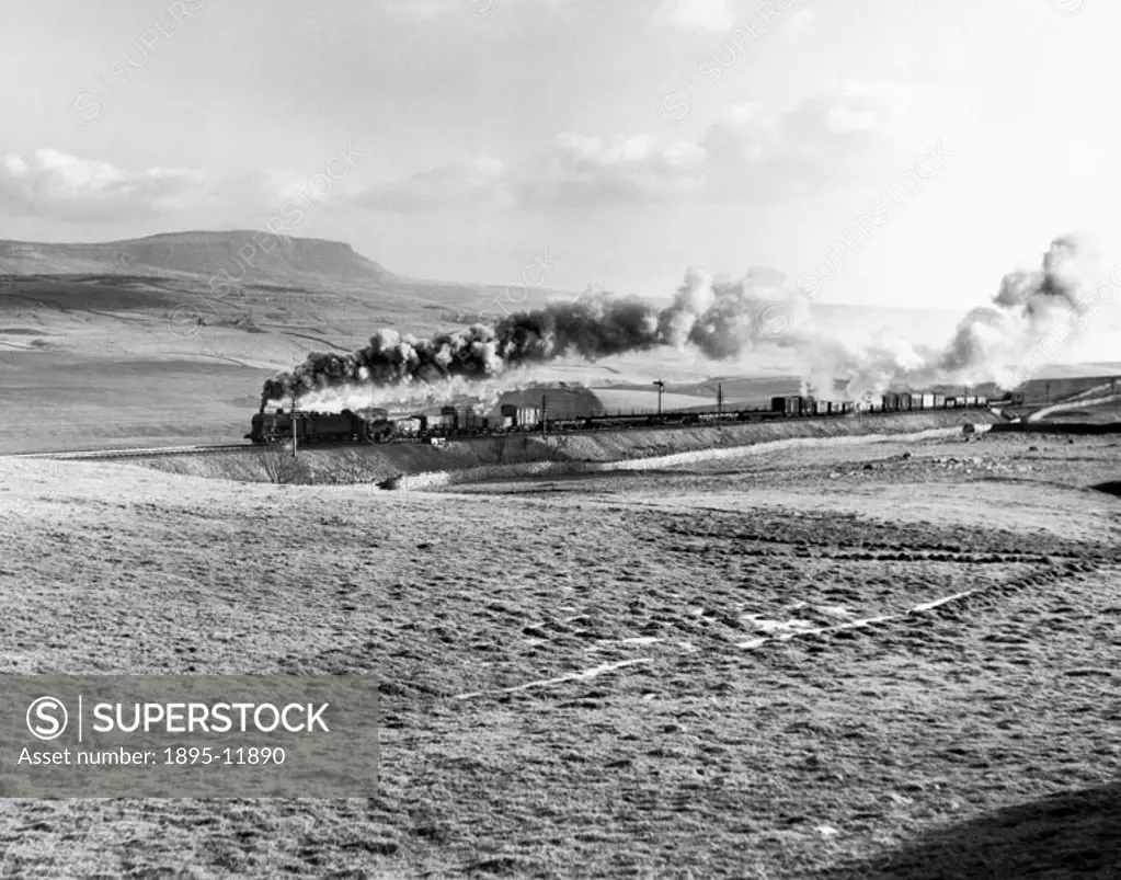 British Railways (BR) steam locomotive with a freight train near Horton-in-Ribblesdale. The slopes of Pen-y-Ghent are visible in the background. Photo...