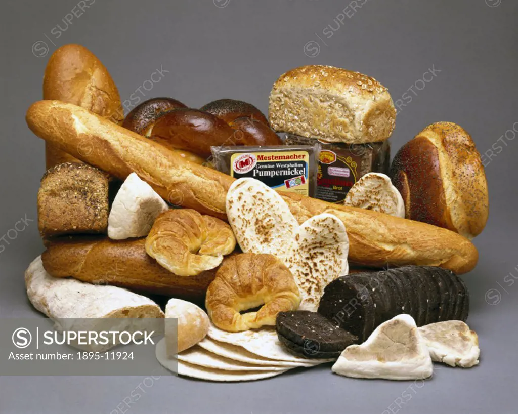 A display of world bread including a French baguette and croissants, Greek pitta bread, German pumpernickel bread, Jewish cholla bread, and flat bread...