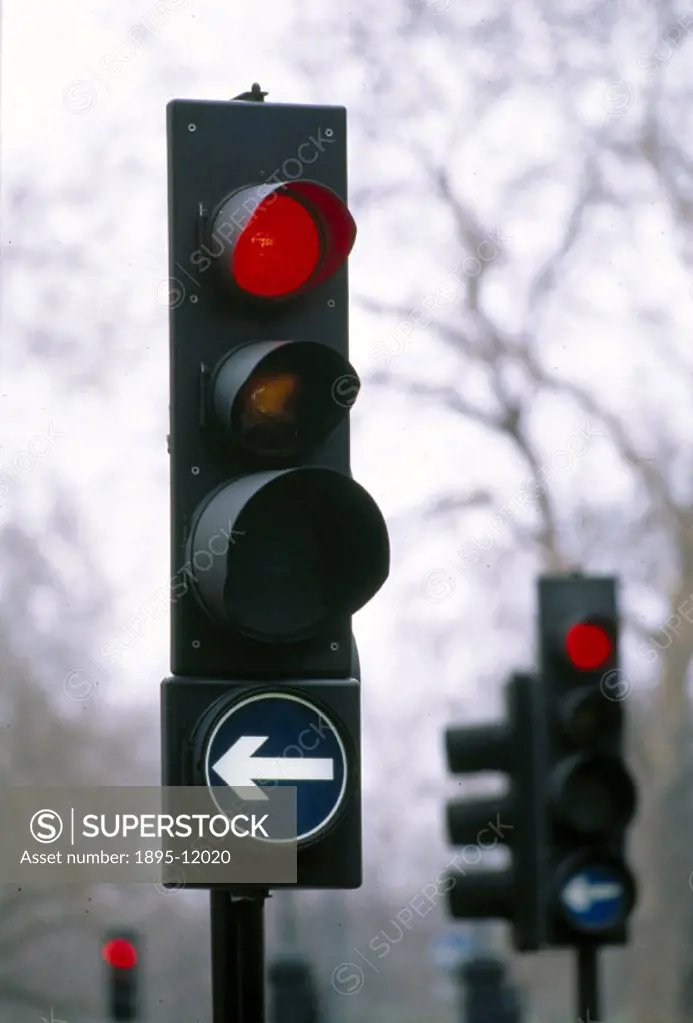Two sets of traffic lights, both showing red, with directional traffic indication signs.