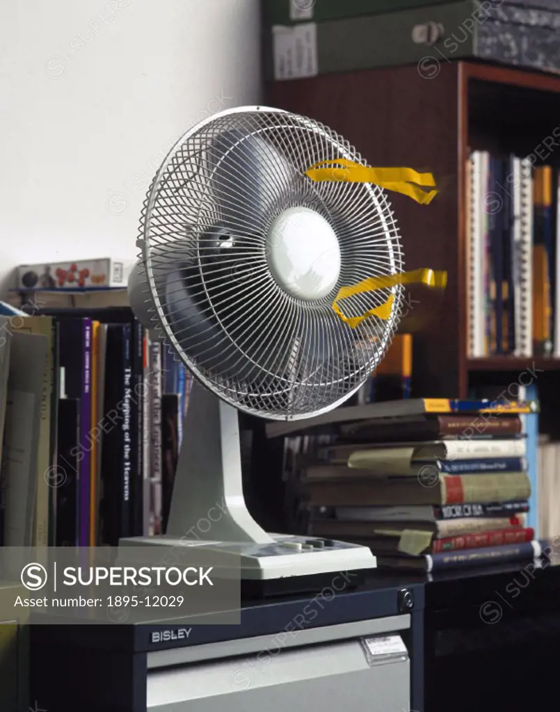 Twelve-inch electric desk fan fan, model STF 12, switched on to demonstrate air movement.