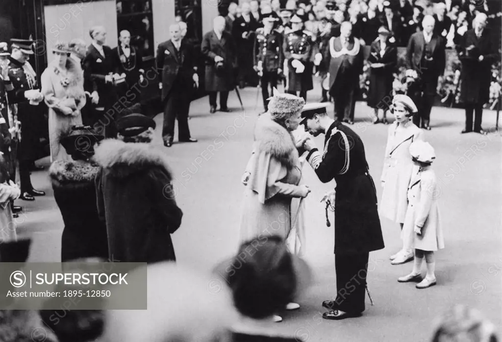 On his return from his North American tour, King George kisses the hand of his mother, Queen Mary, at Waterloo Station. His daughters, Princess Elizab...