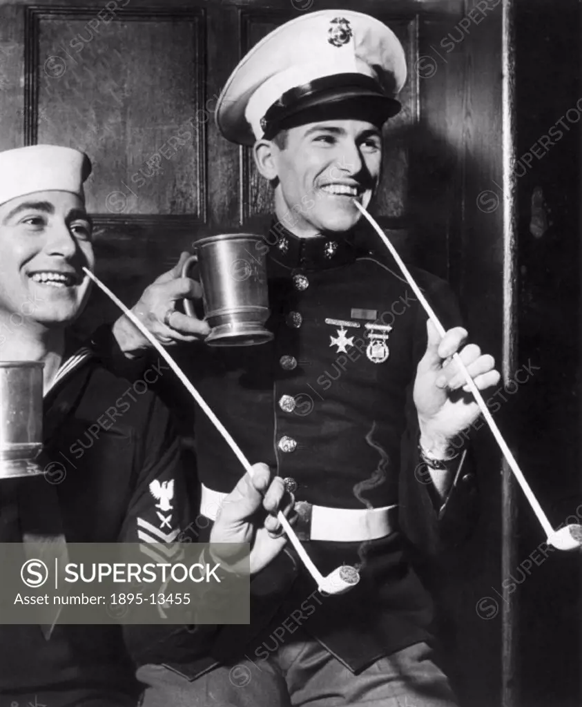 American sailors, probably on leave in Britain during World War Two, smoke traditional clay pipes popular during the 18th century, and drink beer from...