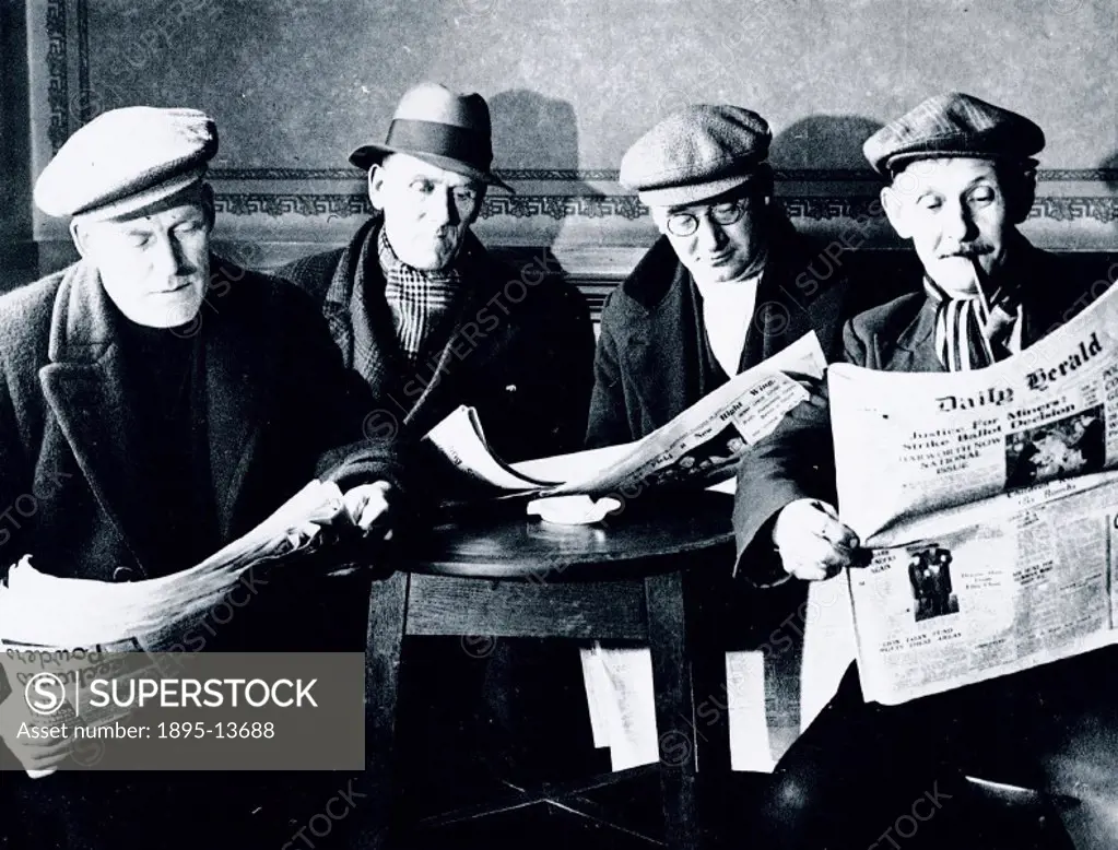 Photograph showing miners on a stay-in-strike, reading the Daily Herald newspaper. Harworth, in common with the whole of the Nottinghamshire coalfield...