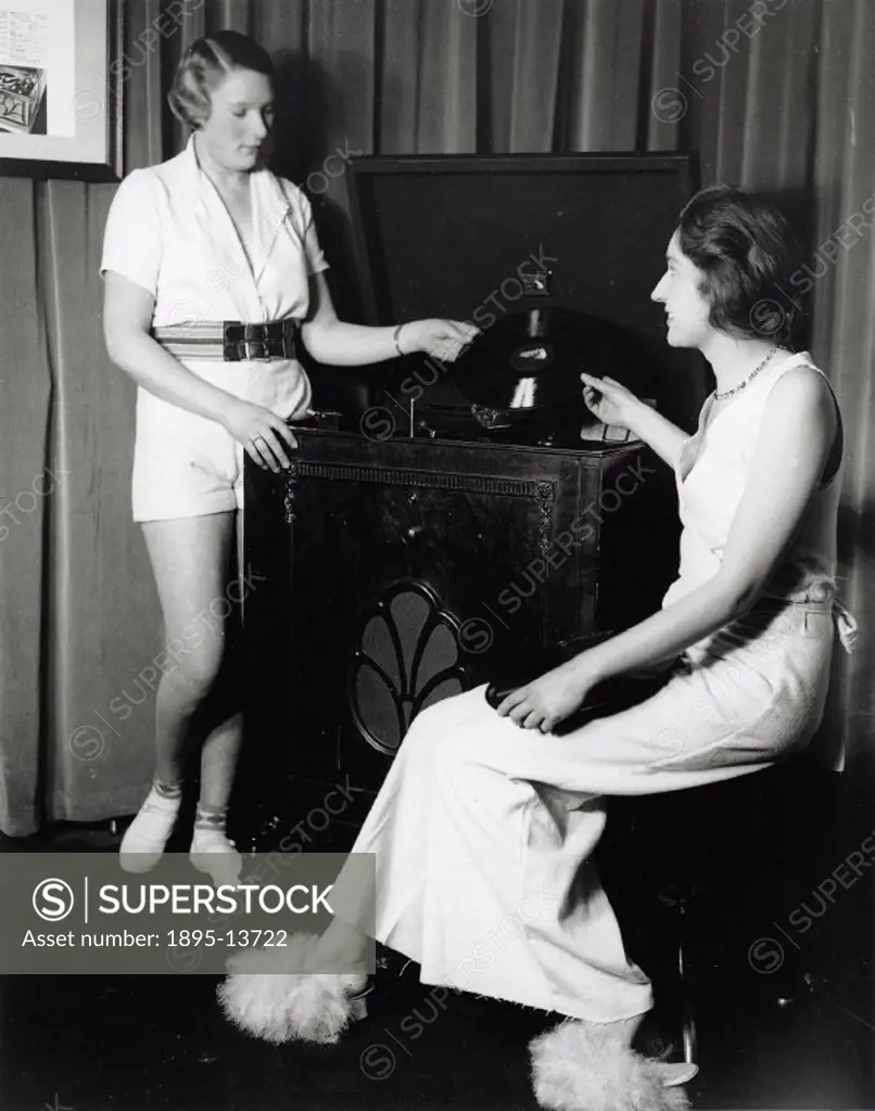 Women posing with the latest HMV gramophone, 31 January 1933. The women are wearing clothes made from new packing cloth. Photograph by Woodbine taken ...