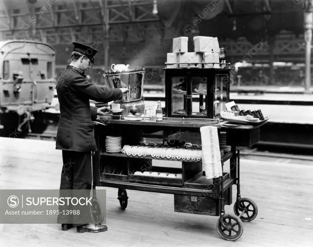 An attendant fills a teacup with boiling water from the urn on the ´Snack Box´ trolley. The trolley contains tea-making equipment, sandwiches and frui...
