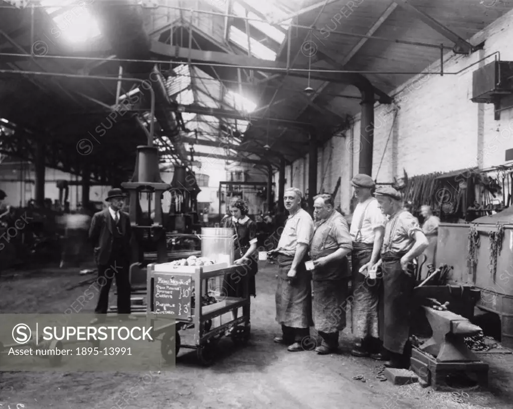These London & North Eastern Railway Workers are being served tea by a tealady in the workshops at Temple Mills while their supervisor watches.