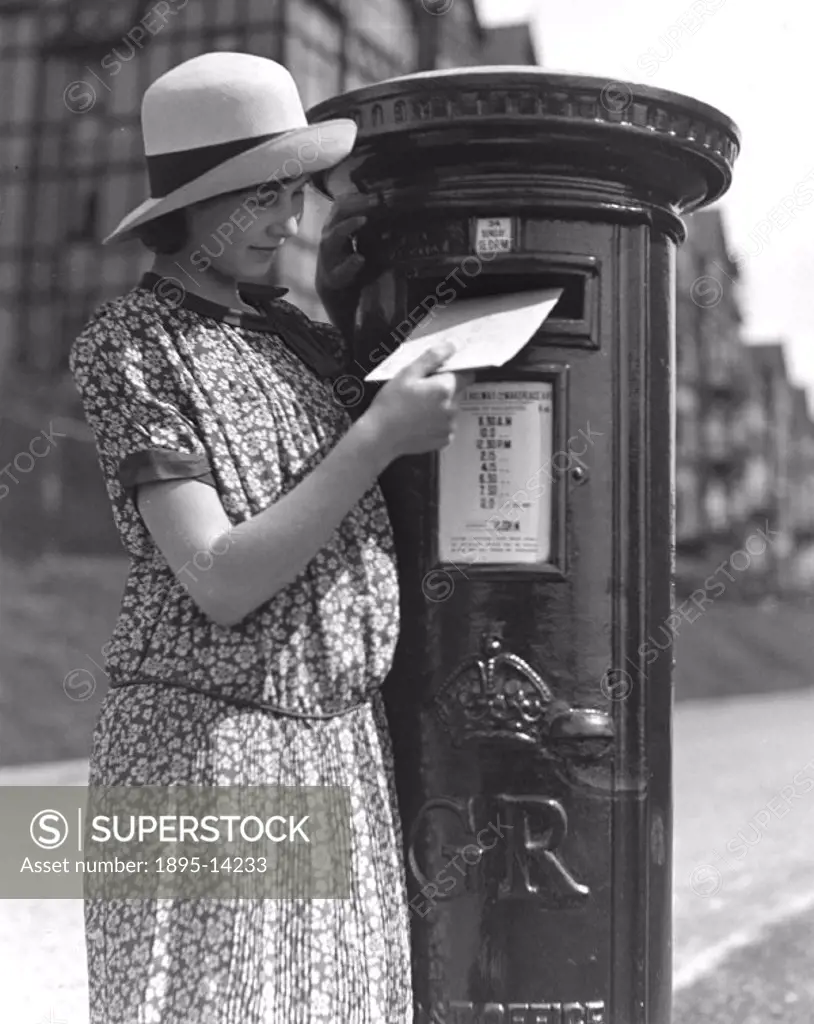 Young woman posting a letter, c 1930s.