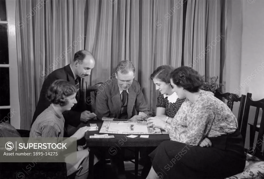 A family playing a game of Monopoly, c 1930.