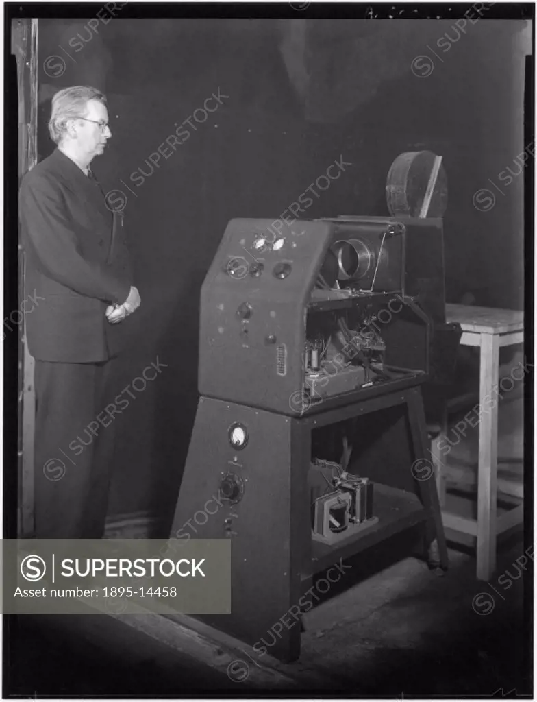 Baird (1888-1946) with his one of his early television projectors, which was used to display BBC outside broadcasts on the cinema screen at the Marble...