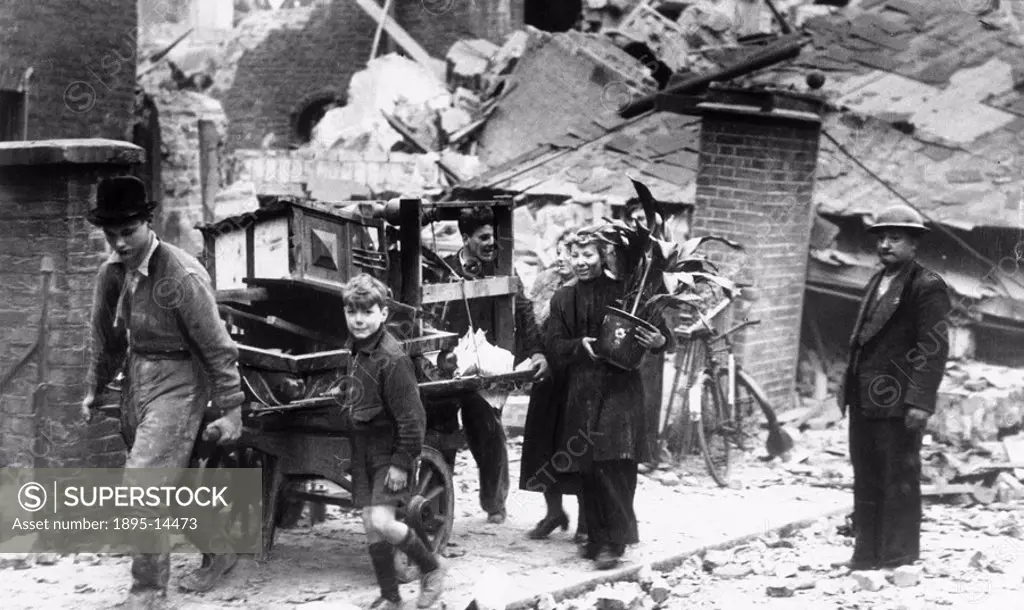 Family carrying belongings from their bombed house, London, 1940 Family carrying their belongings on a hand cart from their bomb wrecked house during ...