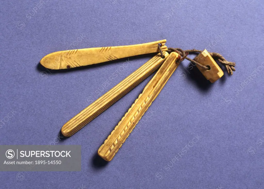 Four ivory objects threaded on string possibly made by the Inuit of the North American Arctic. The Inuit obtain their ivory from walrus tusks.