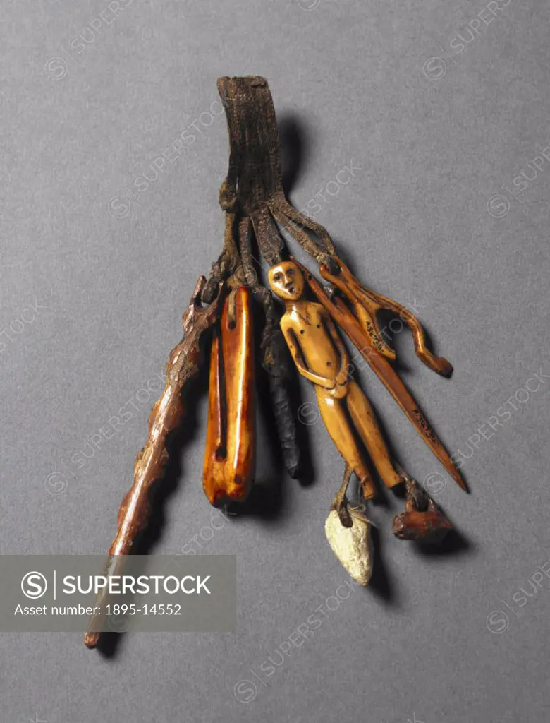 A set of five instruments and a charm attached to a leather thong from the Inuit people of Grand Banks Island, Canada. The items are made from leather...