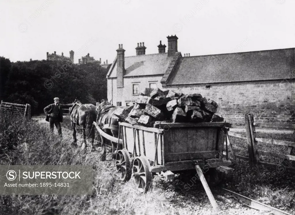 Photograph. Peat is being transported in a horse-drawn railway cart. Belvoir Castle can be seen in the background.