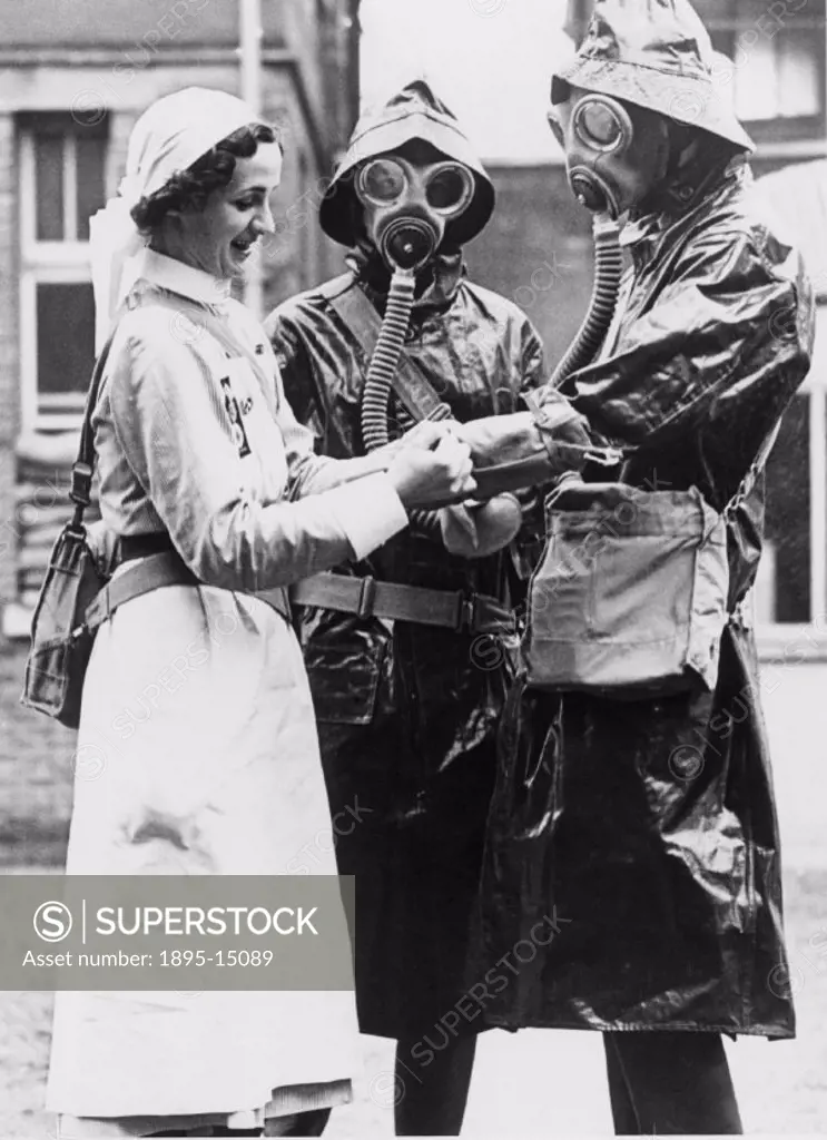 Nurse helping two other nurses to fit their decontamination dress. ´Nurses at the Royal Naval Hospital, Hasler in Portsmouth, have formed their own an...